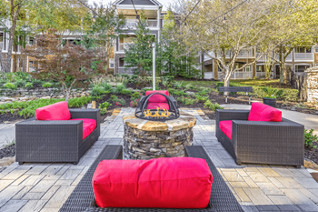 A seating area with a fire pit in the middle of a brick patio